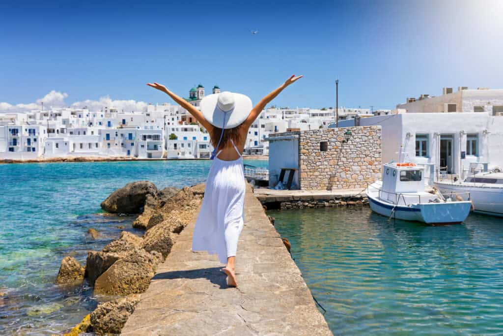 Woman walking along the harbor in Naoussa, Paros island