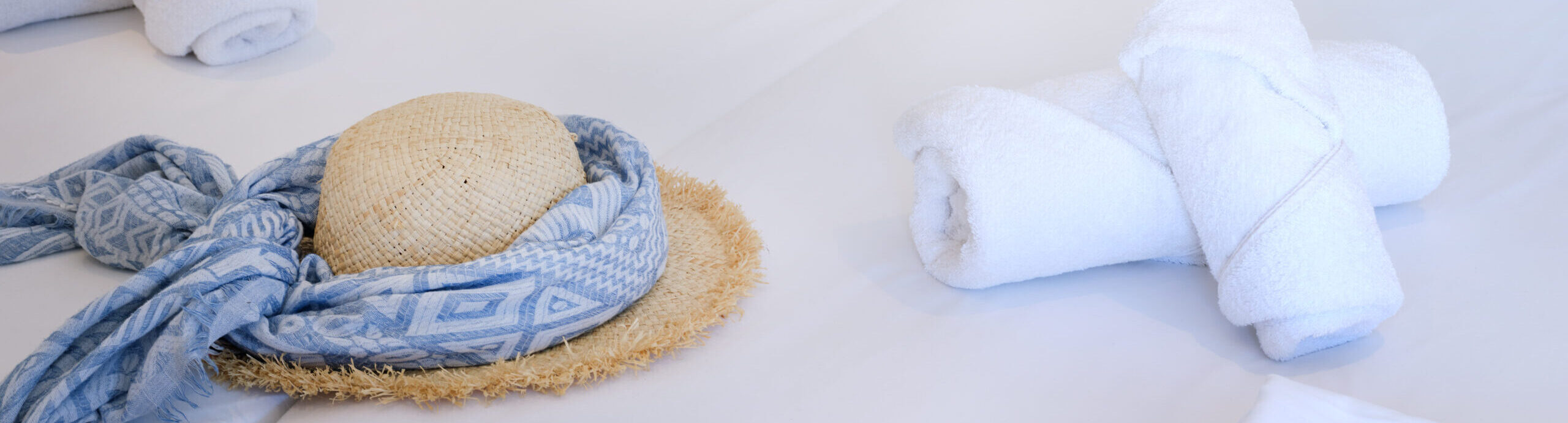 White & Blue room bed setup with sun hats and soft linen in Ambelas, Paros