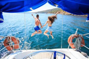 Couple jumping into the sea from a boat in Paros