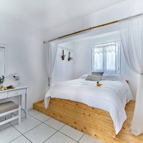 Bright bedroom with double bed and wooden headboard - Cozy Family Apartment Ambelas Paros