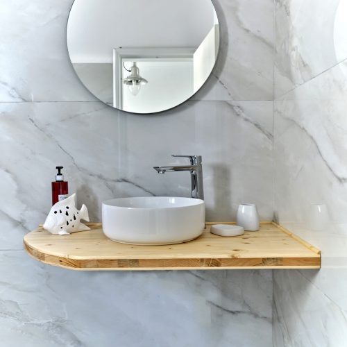 Cozy family apartment bathroom in Ambelas Paros - round mirror and wooden sink detail