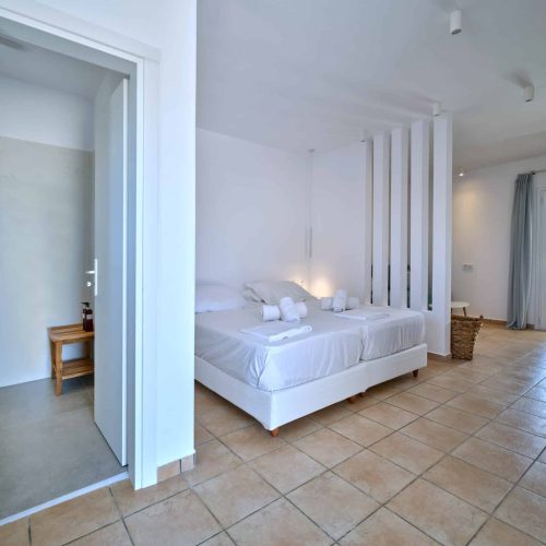 White & Blue room wide bedroom view with natural daylight in Ambelas, Paros