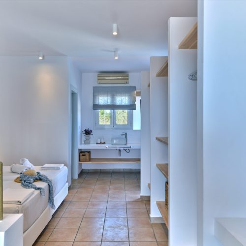 White & Blue room interior with sofa and bright lighting in Paros island