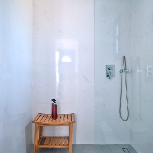 White & Blue room bathroom with glass shower in Paros island
