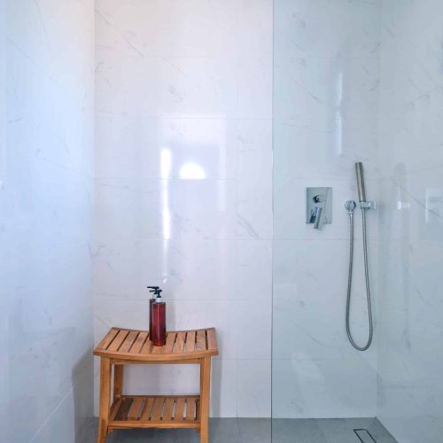 White & Blue room bathroom with glass shower in Paros island