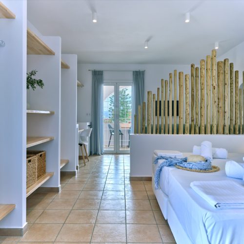 White & Blue room long view showing bedroom and kitchen corner in Paros