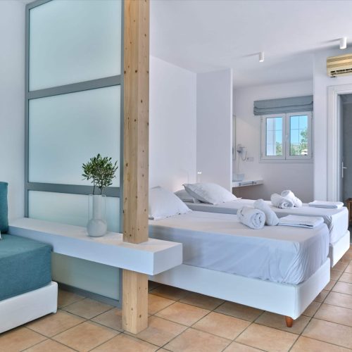 White & Blue room spacious bed and wooden feature wall in Paros island